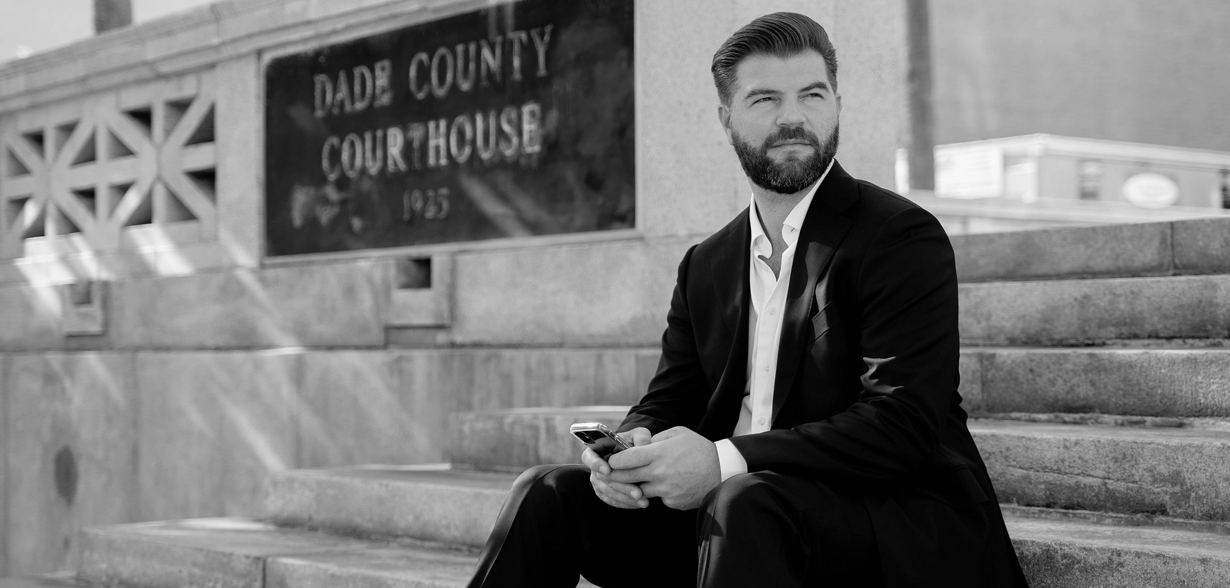 Chris Holtzhauer seated on the steps of the Dade County Courthouse in Miami